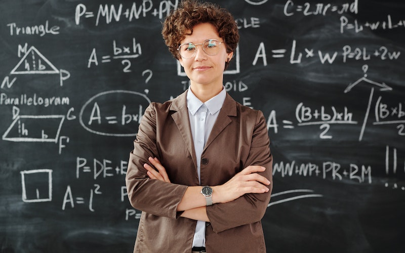 teacher in front of math board