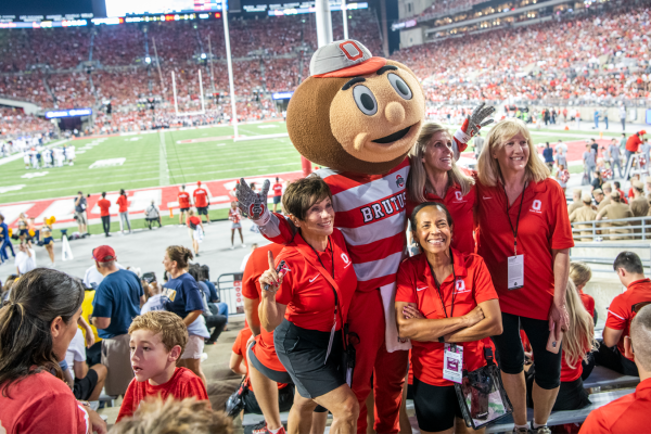Alumni posing with Brutus at a football game