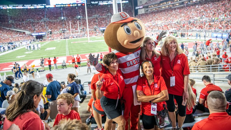 Alumni posing with Brutus at a football game