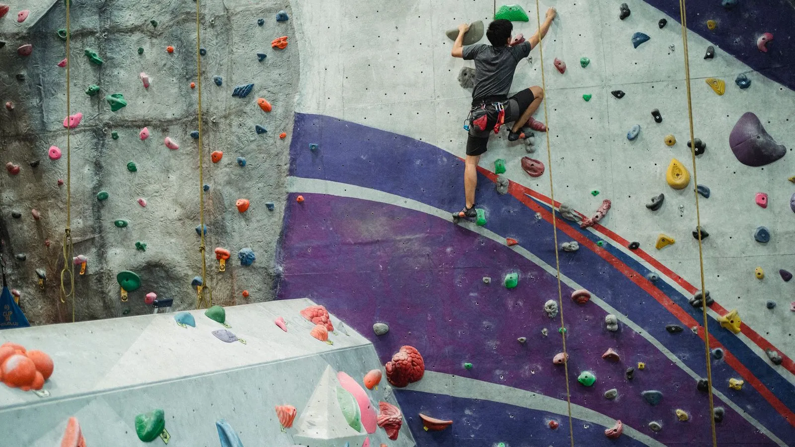 Man climbing on a wall in a rock climbing gym