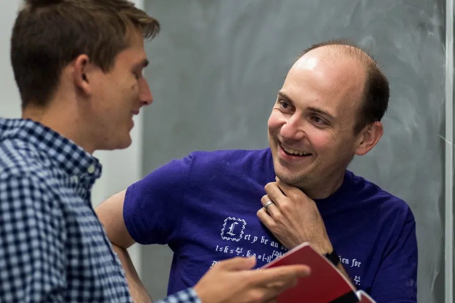 Two graduate students work on a project