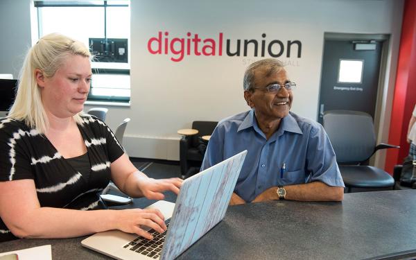 Faculty helping a local business owner