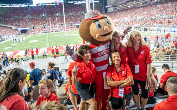 alumni at football game posing with Brutus