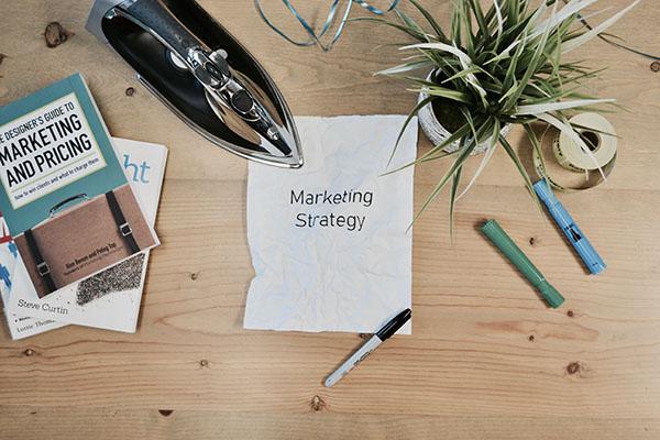 Paper stating "Marketing Strategy" on a messy desk