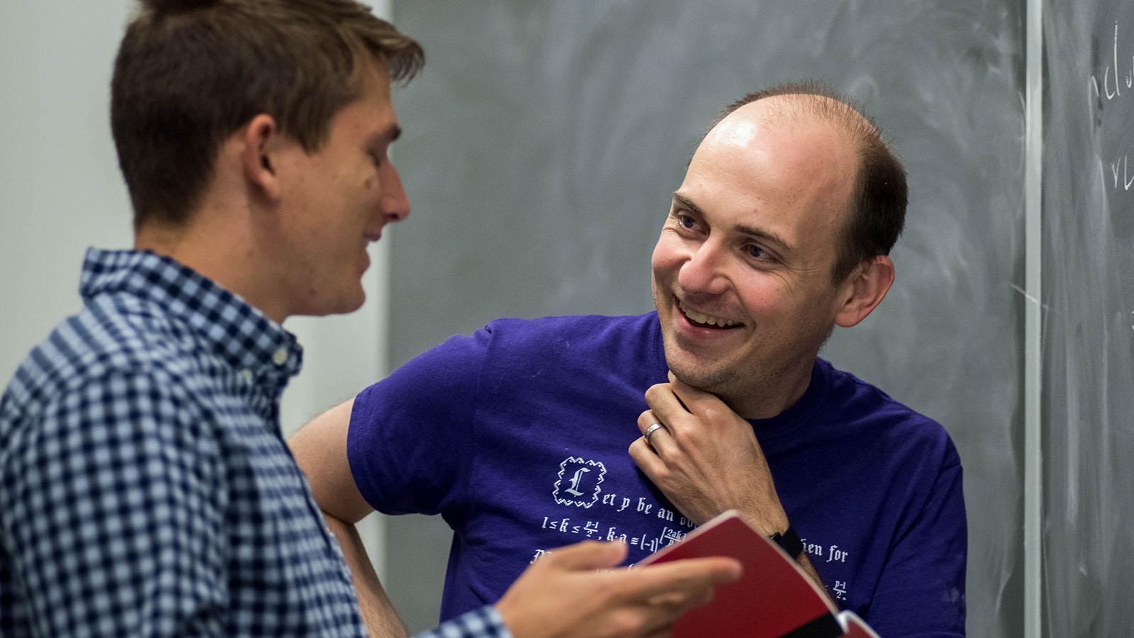 Two graduate students work on a project