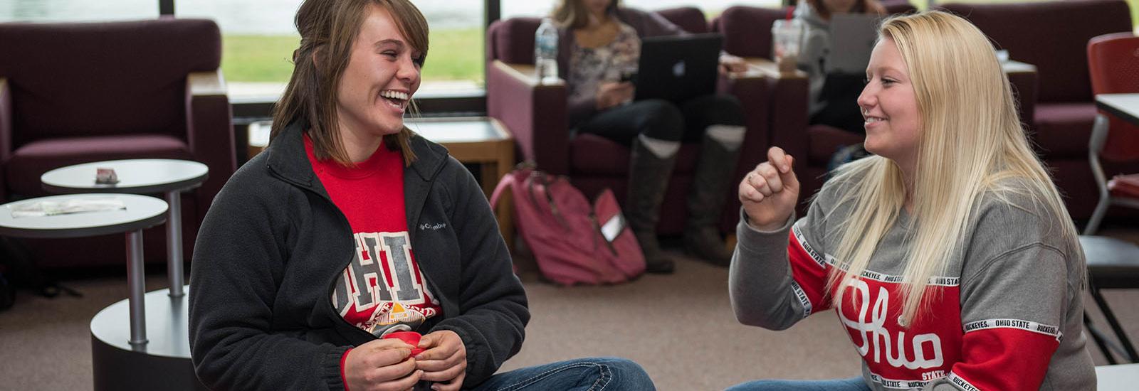 Two students converse at Thompson library