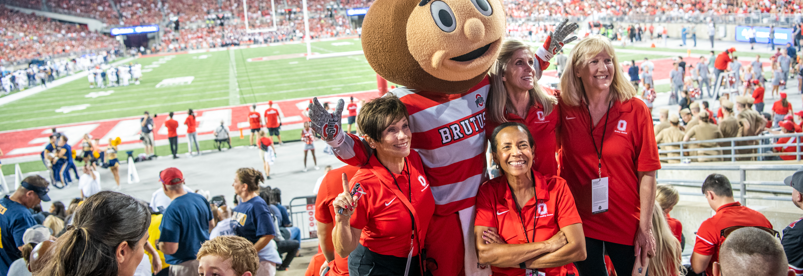 Alumni posing with Brutus at a football game